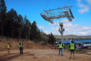 A cross arm being lowered via helicopter on to one of Angel Express' towers.